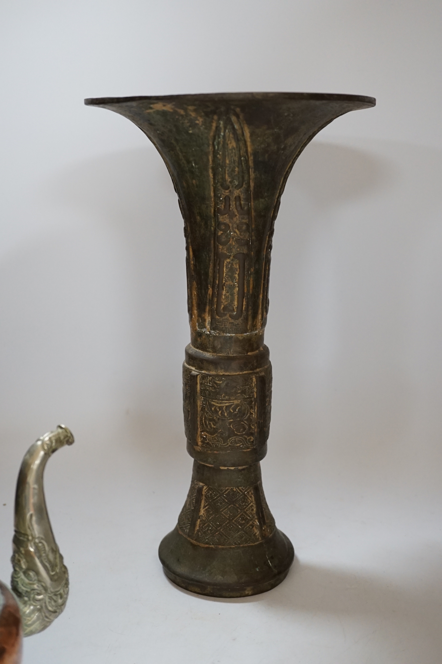 A Chinese bronze gu vase, a 19th century Chinese blue and white vase and a Tibetan teapot, tallest 34cm